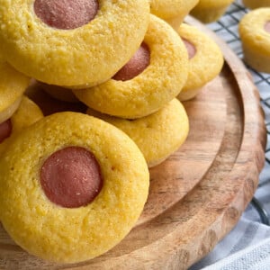 Corndog bites stacked on a wooden plate