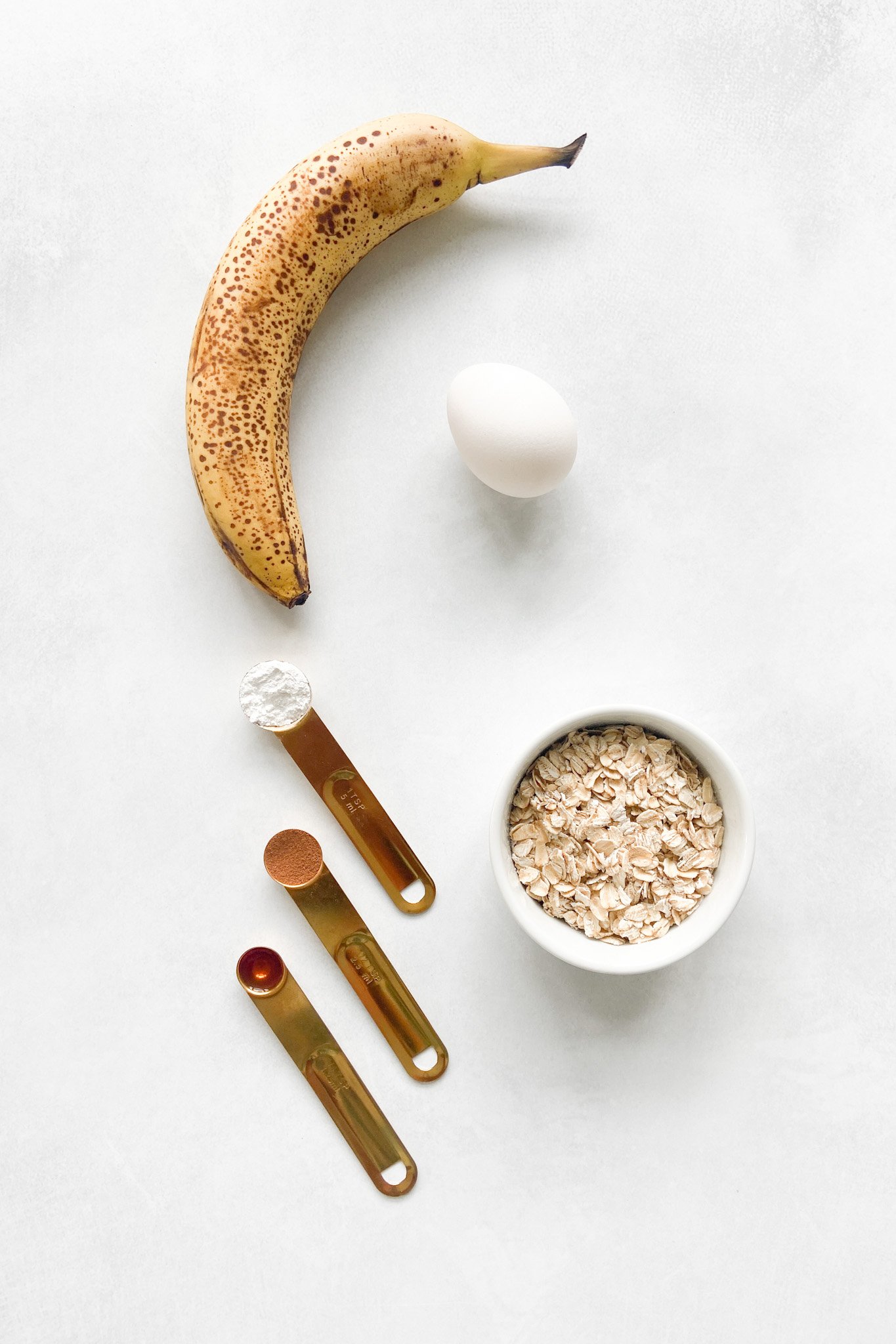 Ingredients to make oatmeal banana pancakes. Specifics provided in recipe card.