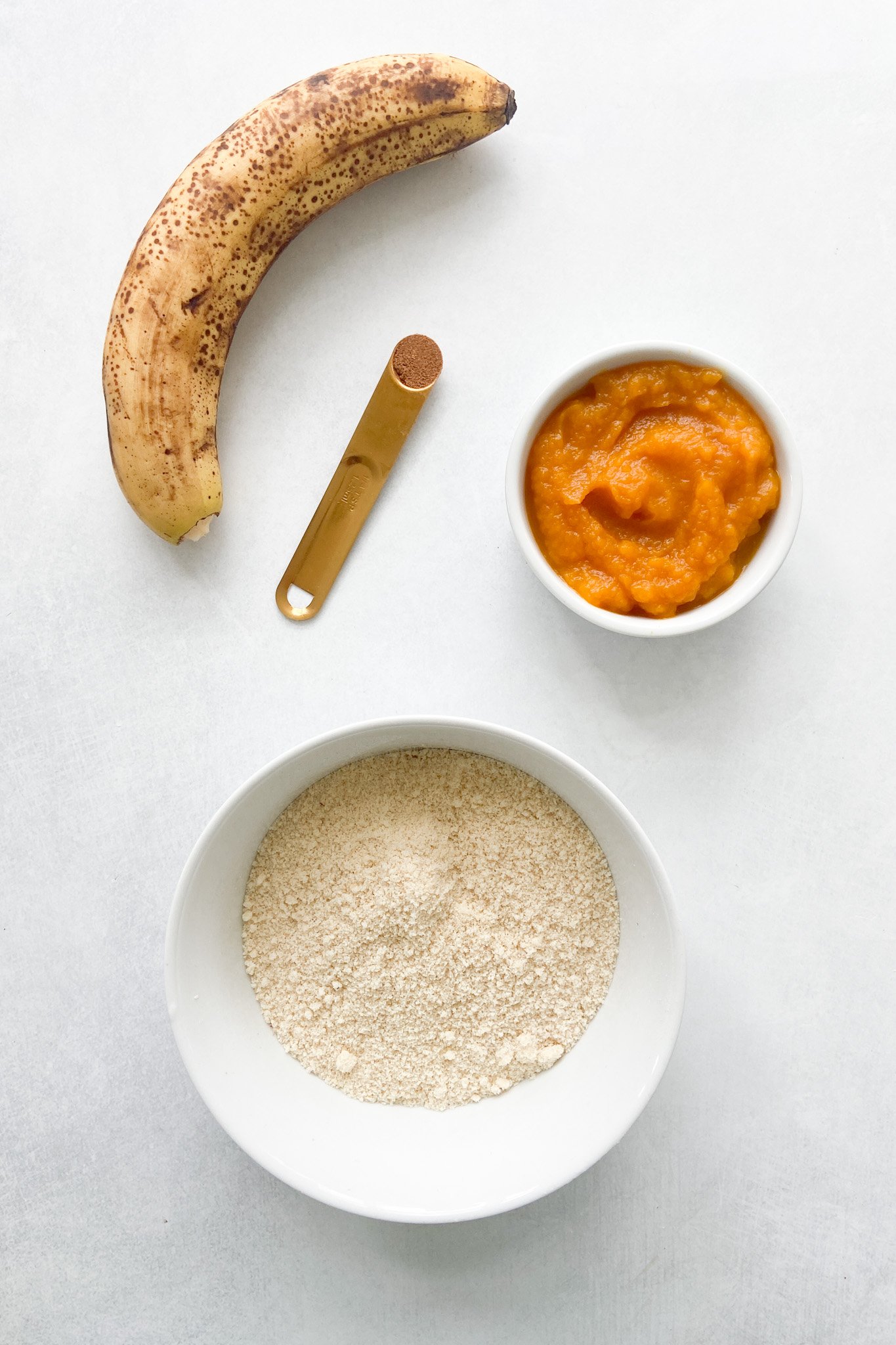 Ingredients to make pumpkin banana cookies. See recipe card for detailed ingredient quantities.