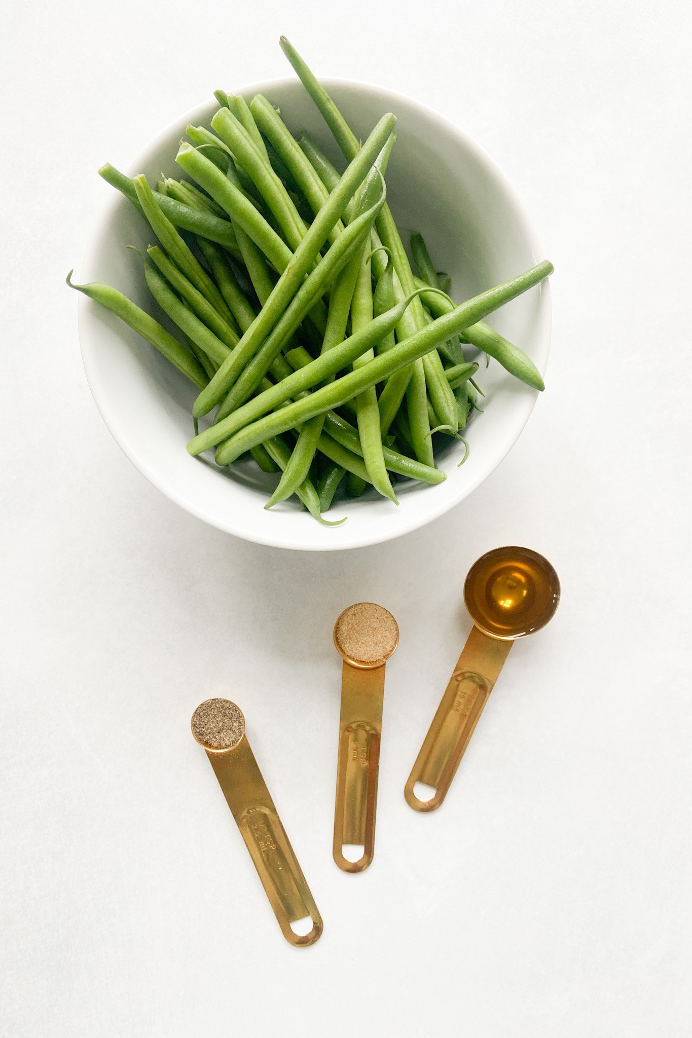 Ingredients to make air fryer green beans. See recipe card for detailed ingredient quantities.