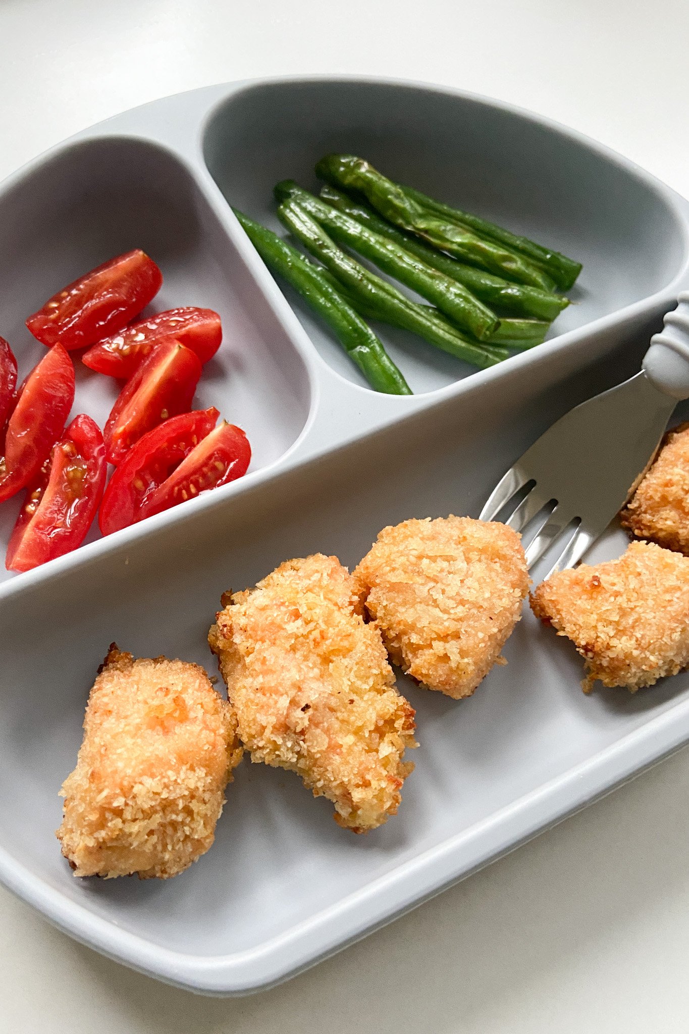 Salmon nuggets served with quartered tomatoes and green beans