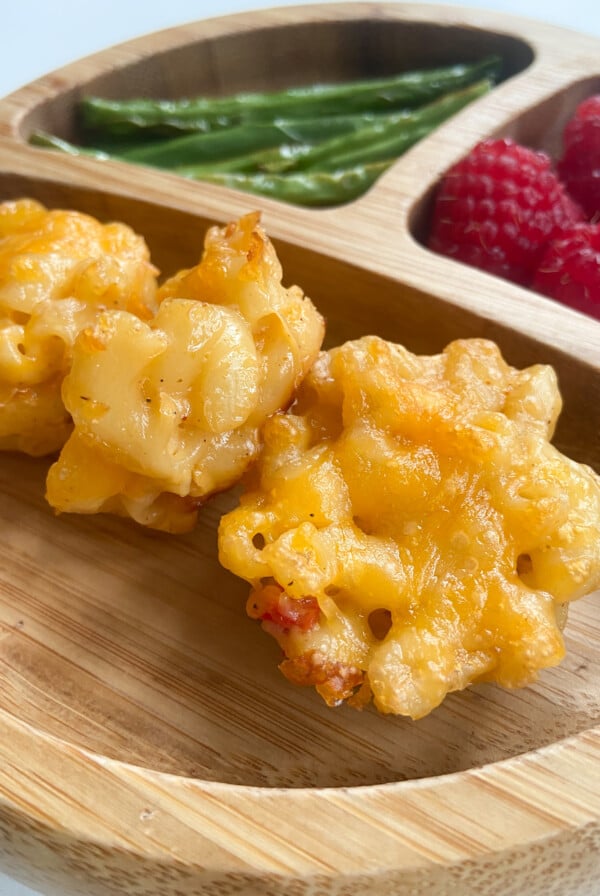 Mac and cheese bites served with green beans and raspberries