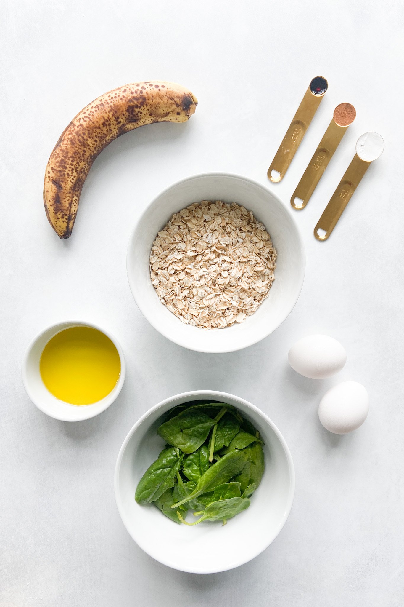 Ingredients to make spinach banana pancakes. See recipe card for detailed ingredient quantities.