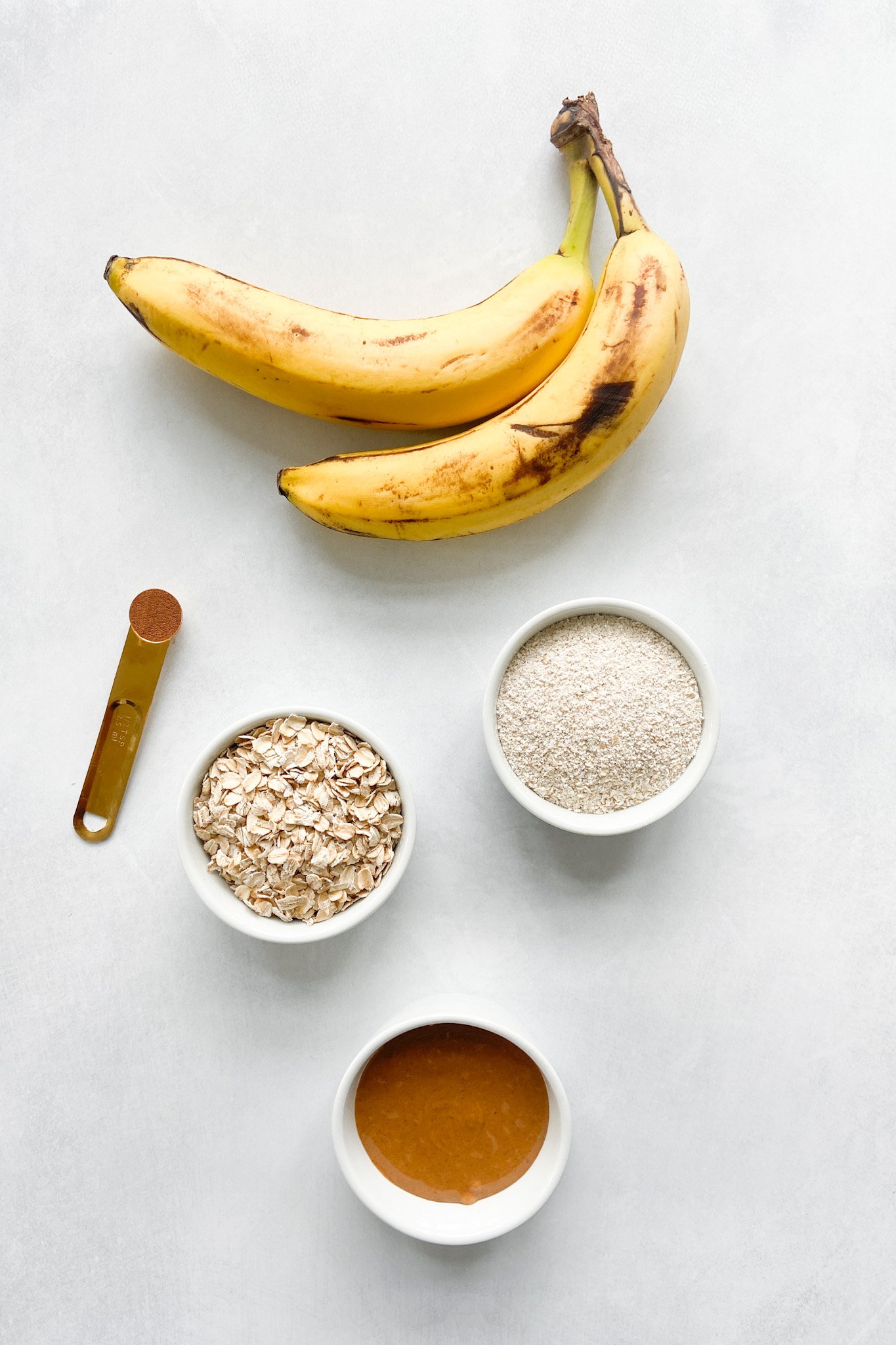 Ingredients to make peanut butter and banana cookies. See recipe card for detailed ingredient quantities.