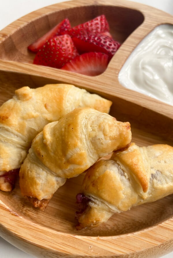 Mini blueberry croissants served with sliced strawberries and yogurt