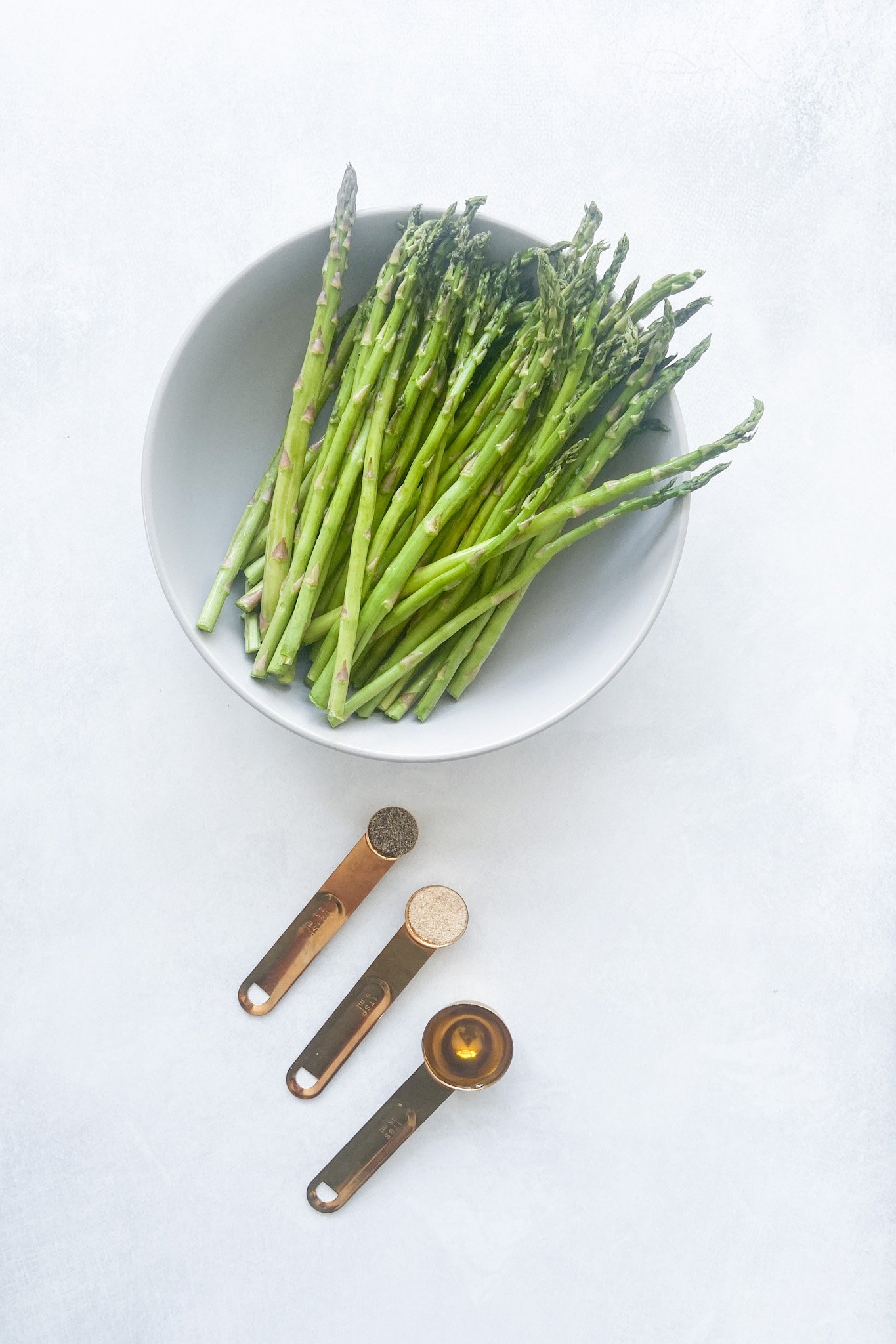 Ingredients to make air fryer asparagus. See recipe card for detailed ingredient quantities.
