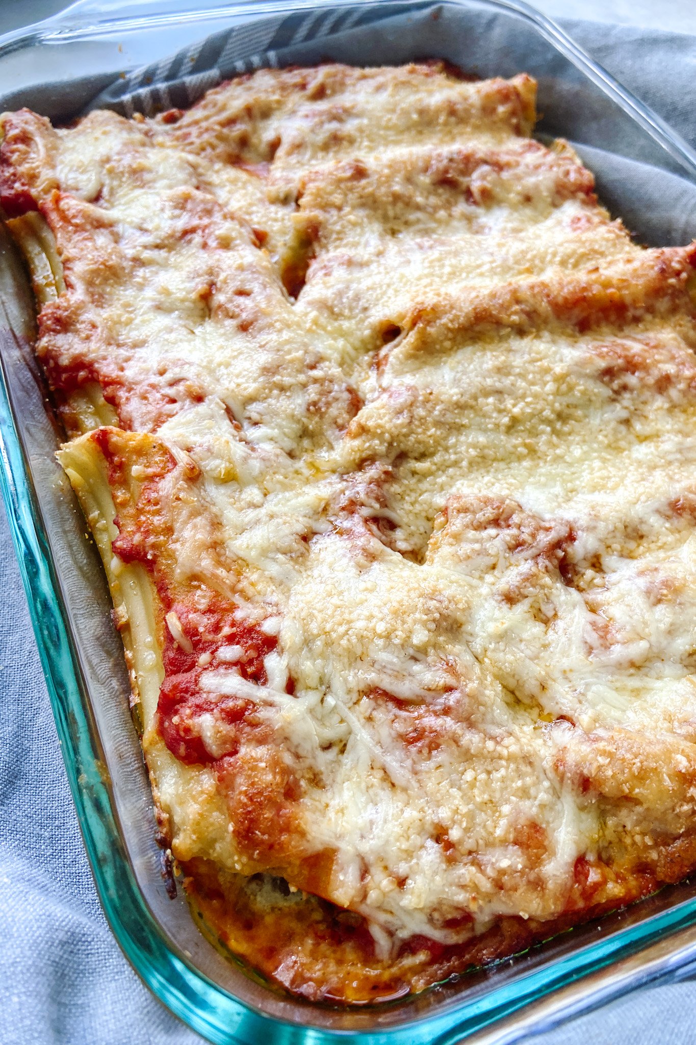 Cheesy beef manicotti fresh out of the oven in a pyrex tray