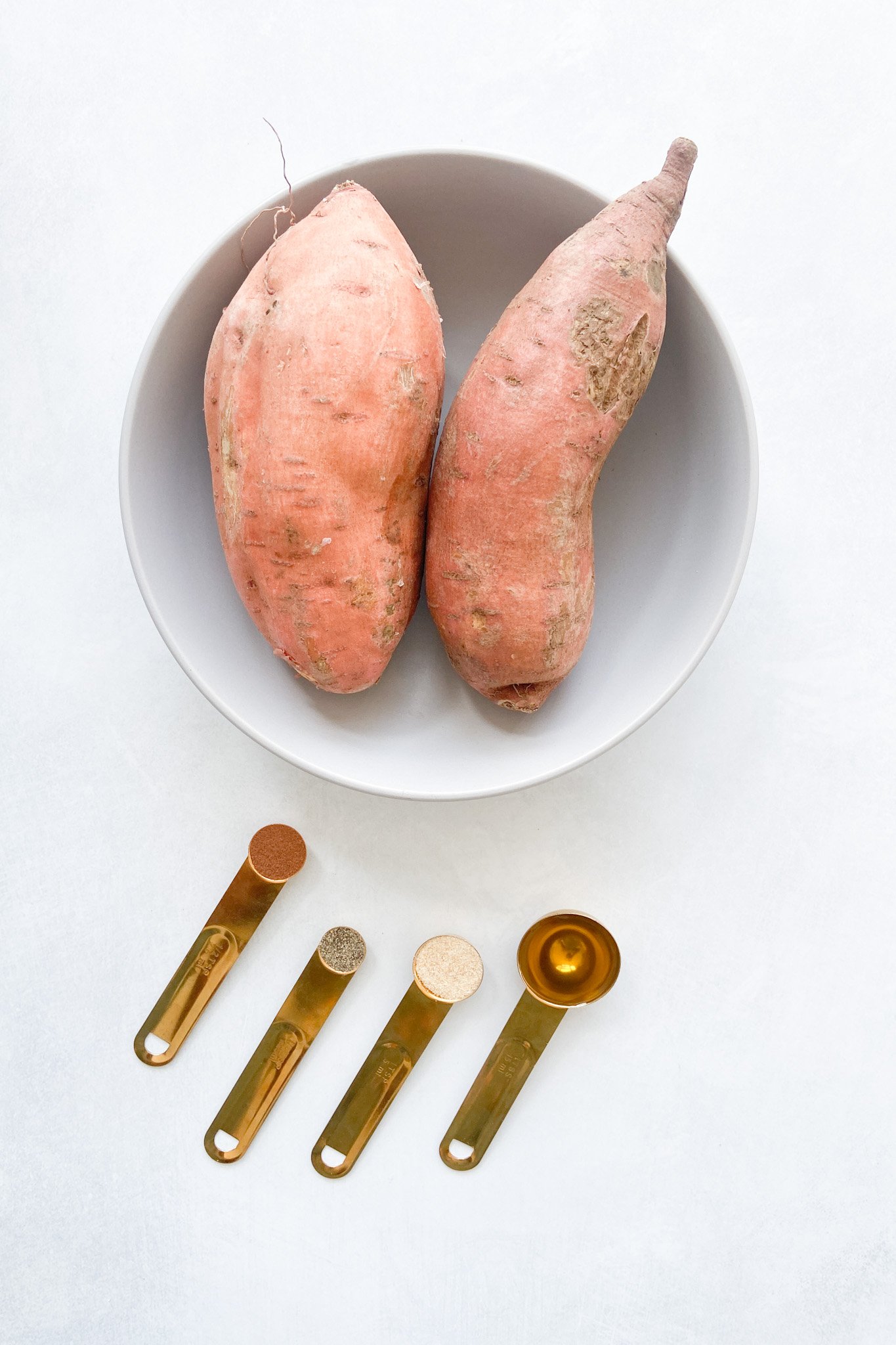 Ingredients to make air fryer sweet potatoes. See recipe card for detailed ingredient quantities.