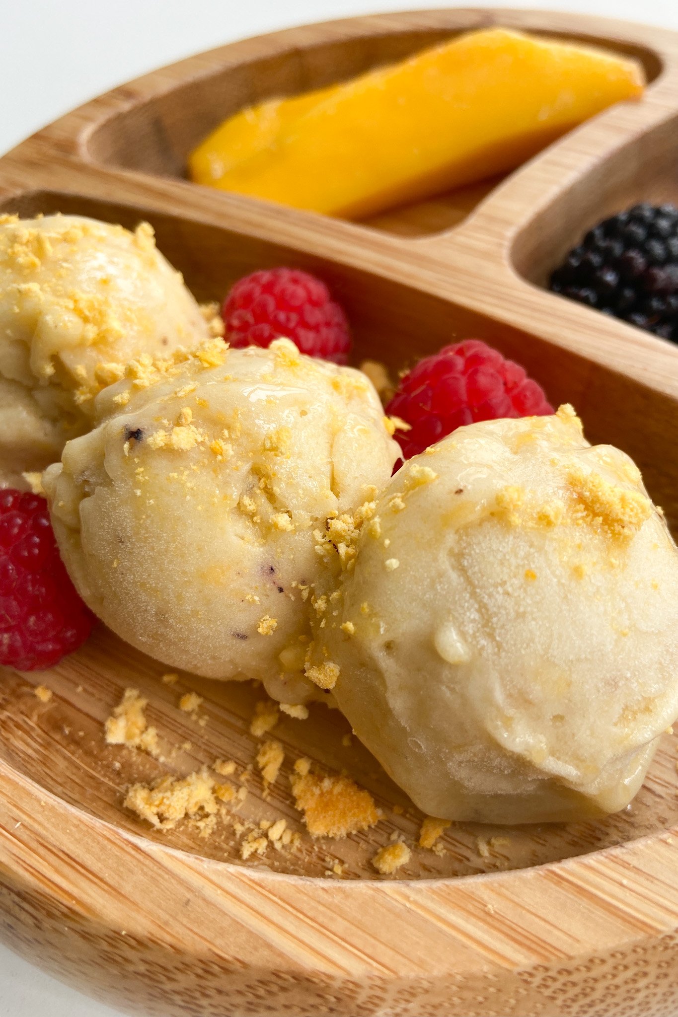 Mango banana nice cream served with sliced mangoes, blackberries and raspberries