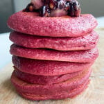 Beet banana pancakes topped with crushed blackberries