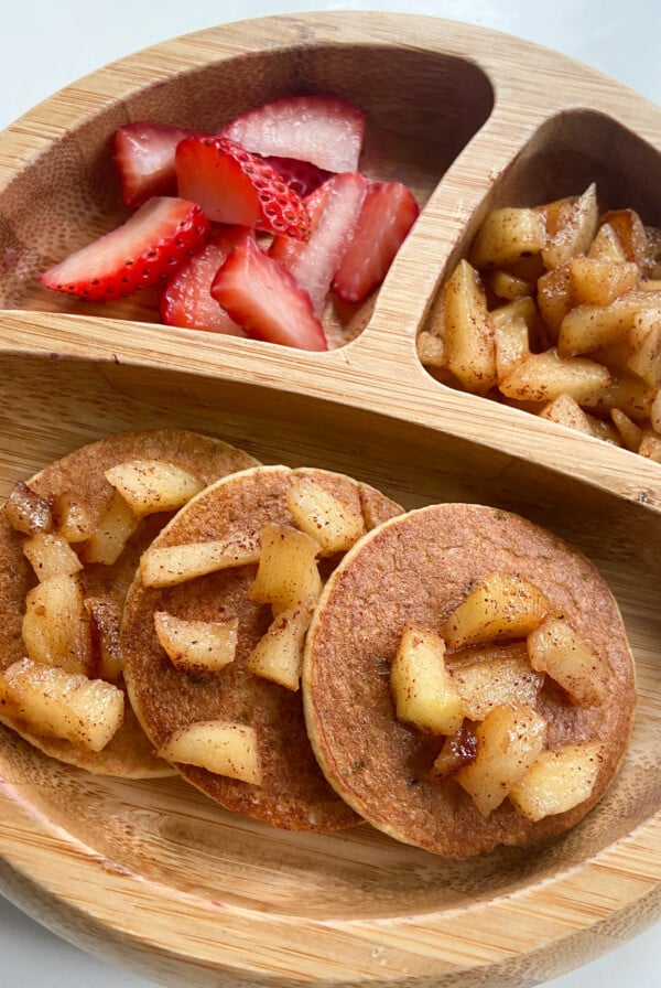 Cinnamon apple pancakes served with strawberries and cinnamon apples