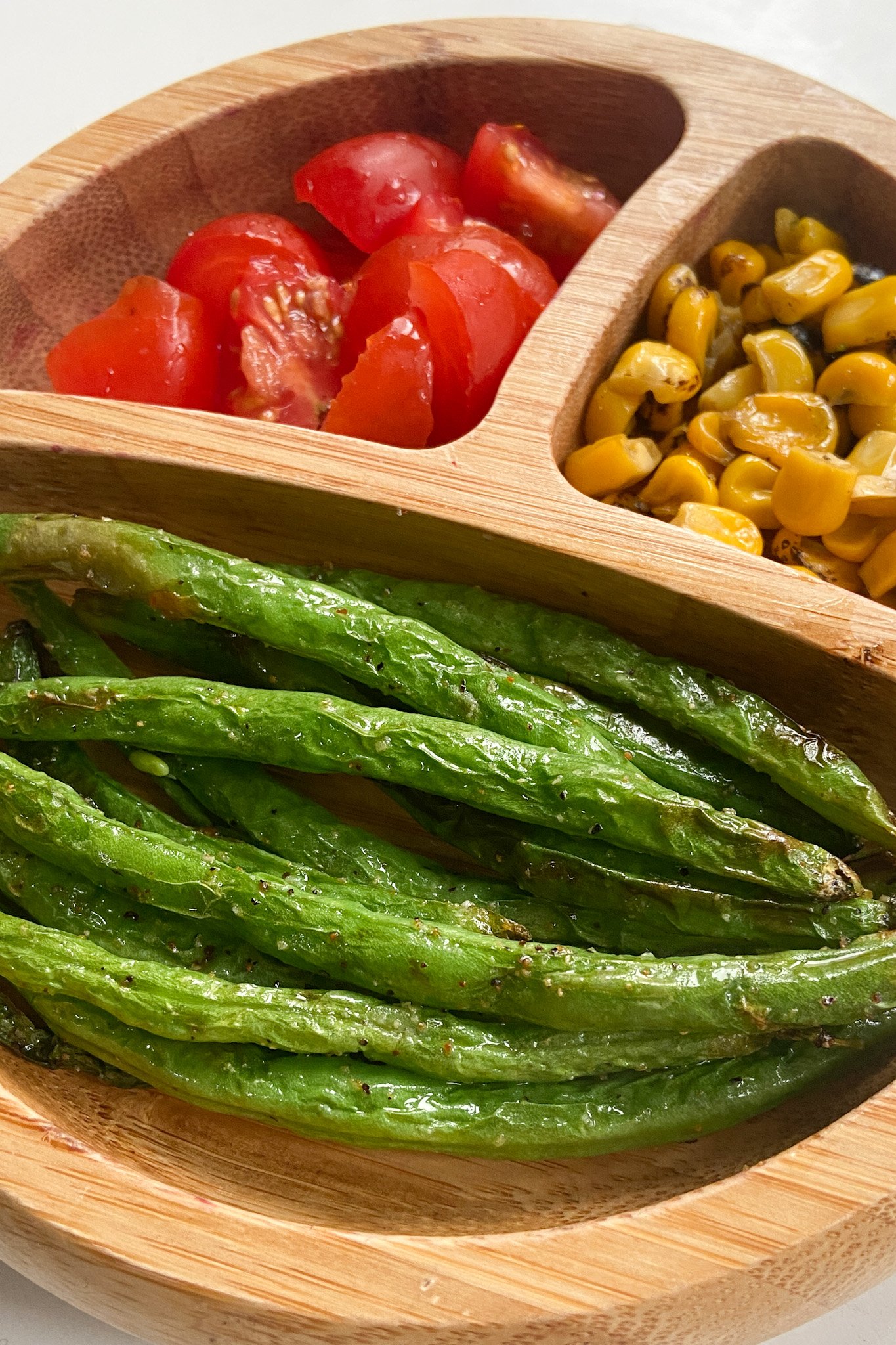 Air fryer gold green beans served with quartered grape tomatoes and roasted corn