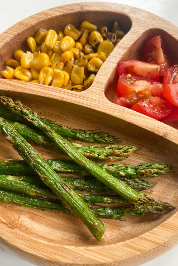 Air fried asparagus served with roasted corn and quartered tomatoes