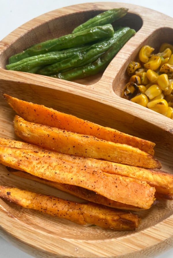Air fryer sweet potatoes served with green beans and roasted corn