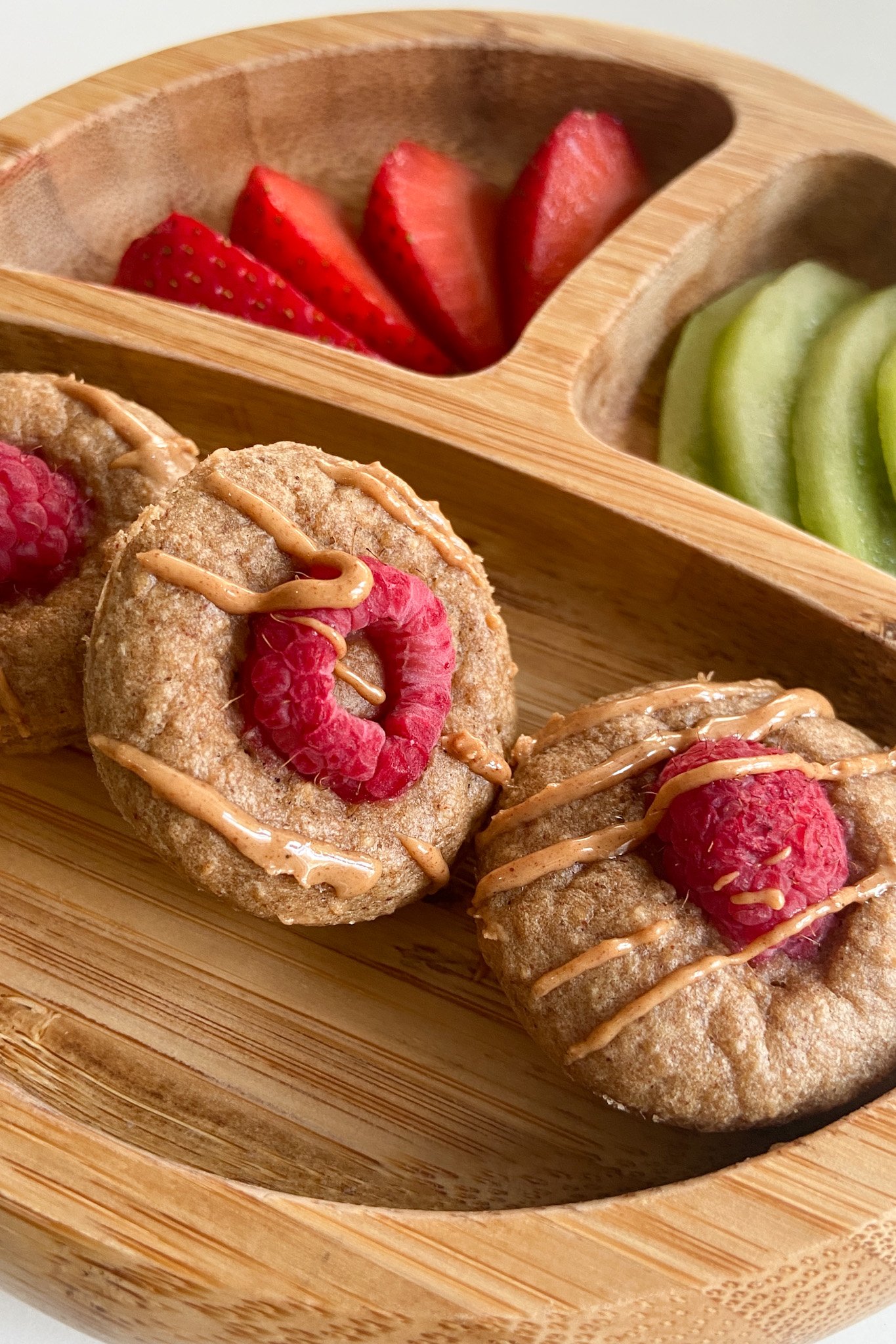 Peanut butter and jelly muffins served with sliced strawberries and kiwi