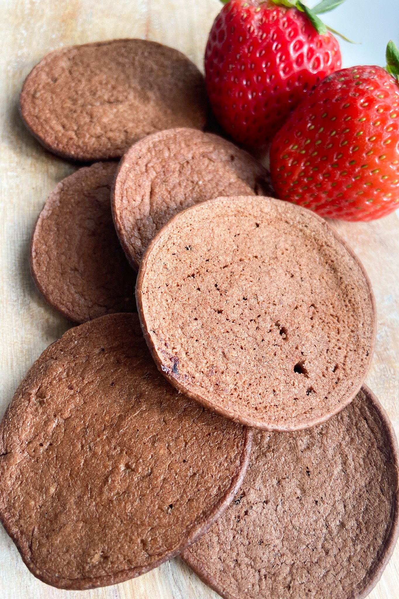 Chocolate banana pancakes served with a side of strawberries