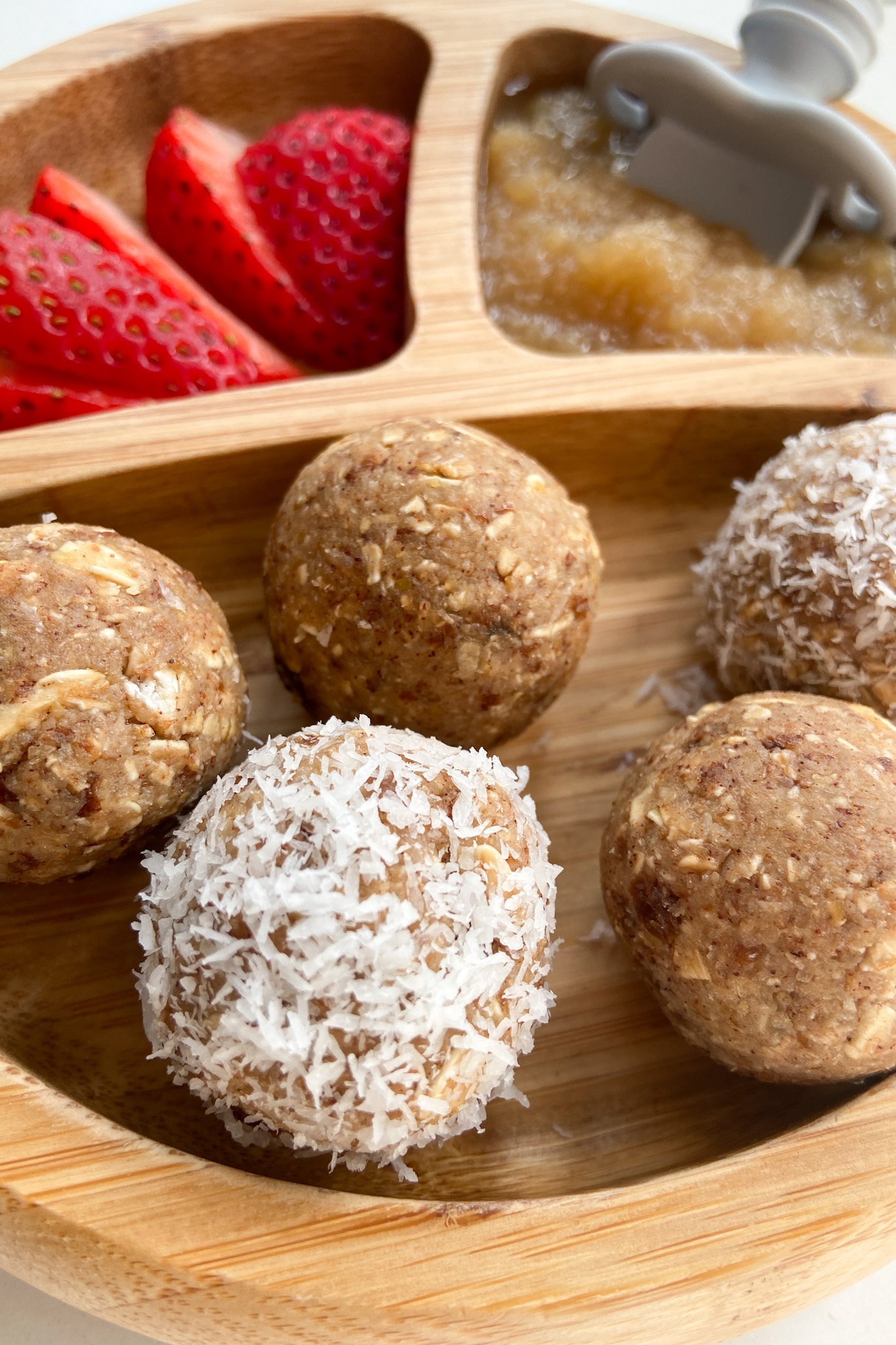 Apple pie bliss balls served with sliced strawberries and applesauce