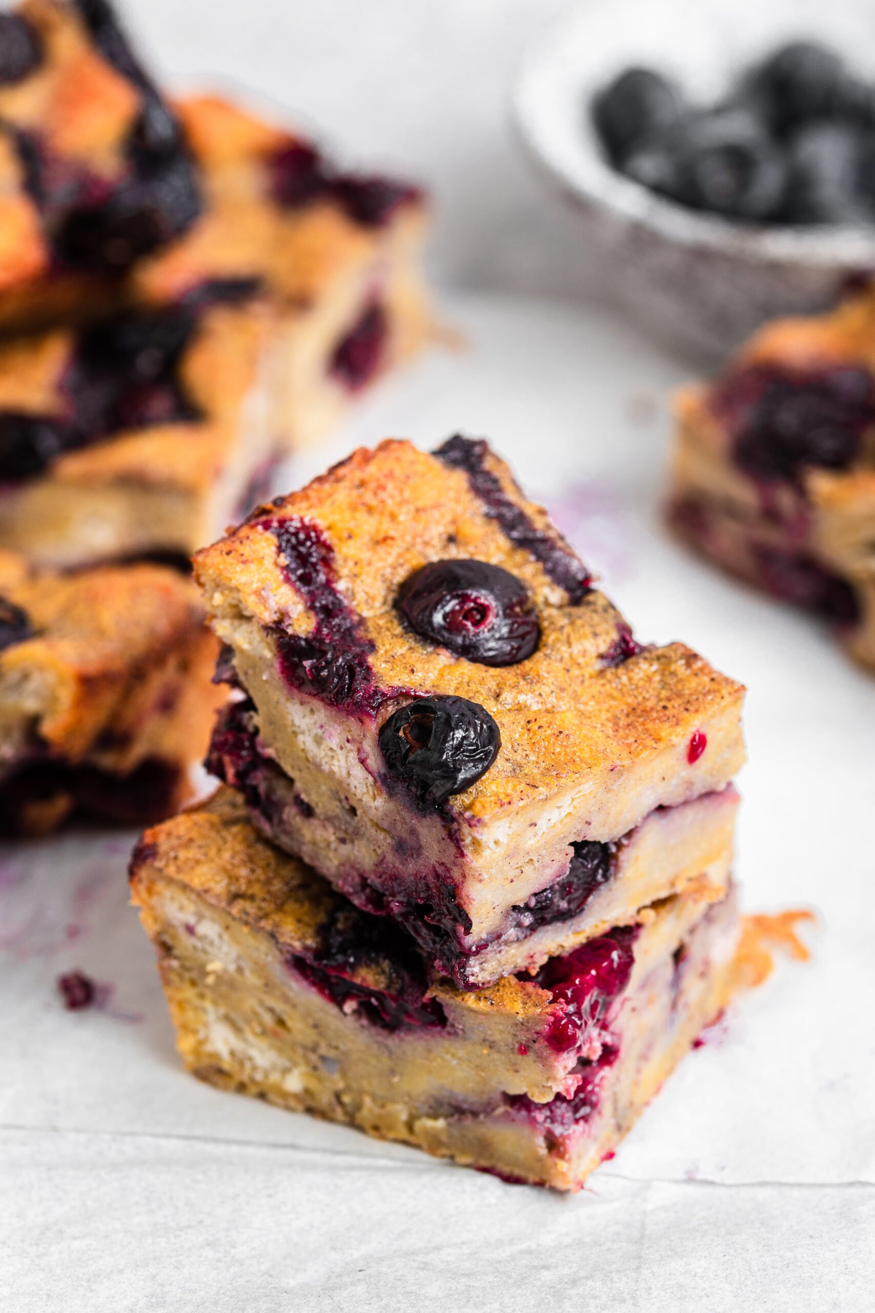 Blueberry French toast bake split into small pieces. Served with blueberries