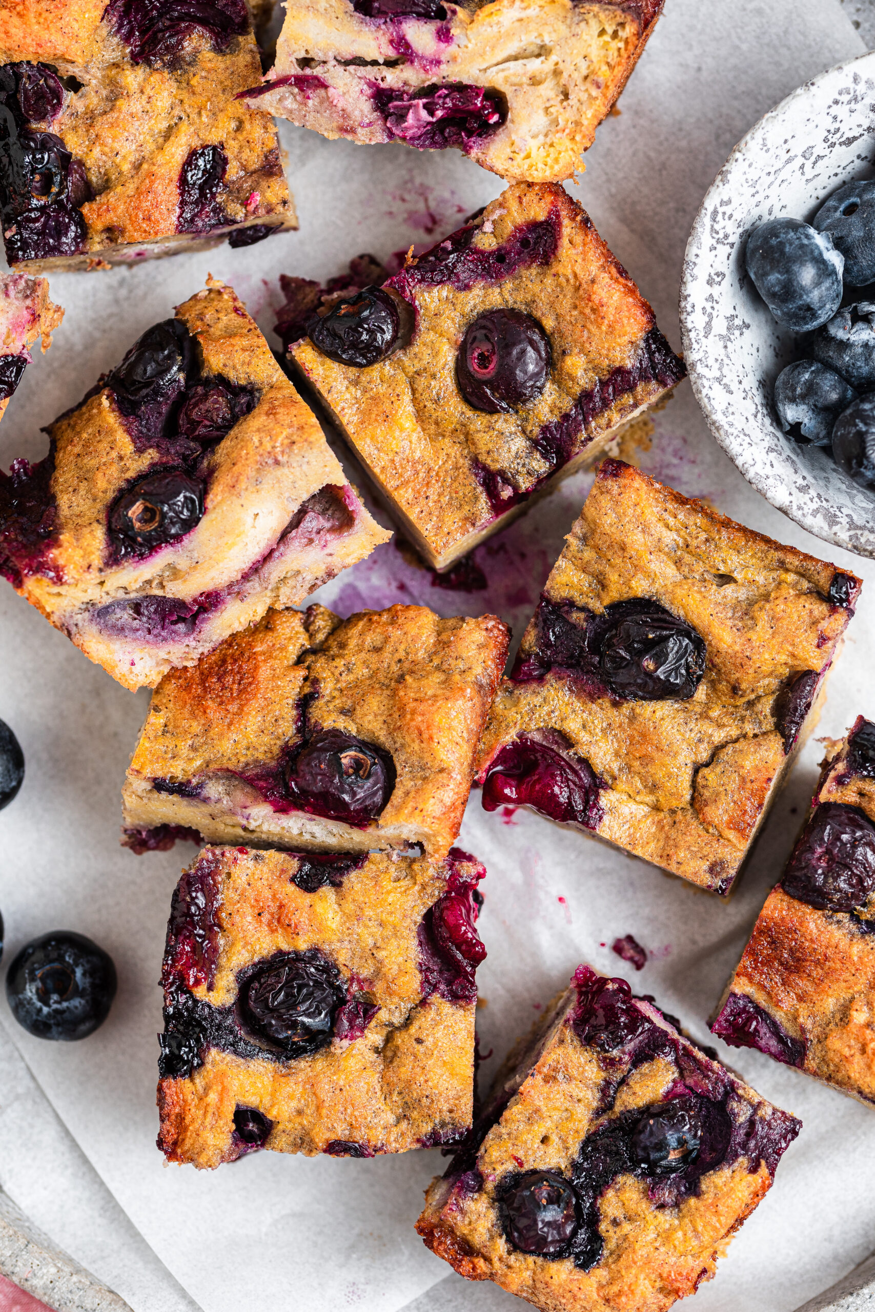 Blueberry French toast bake split into small pieces. Served with blueberries