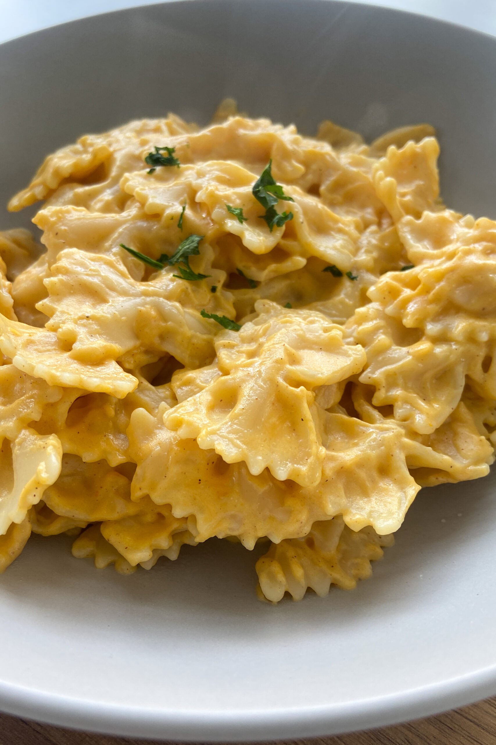Creamy pumpkin pasta garnished with parsley flakes