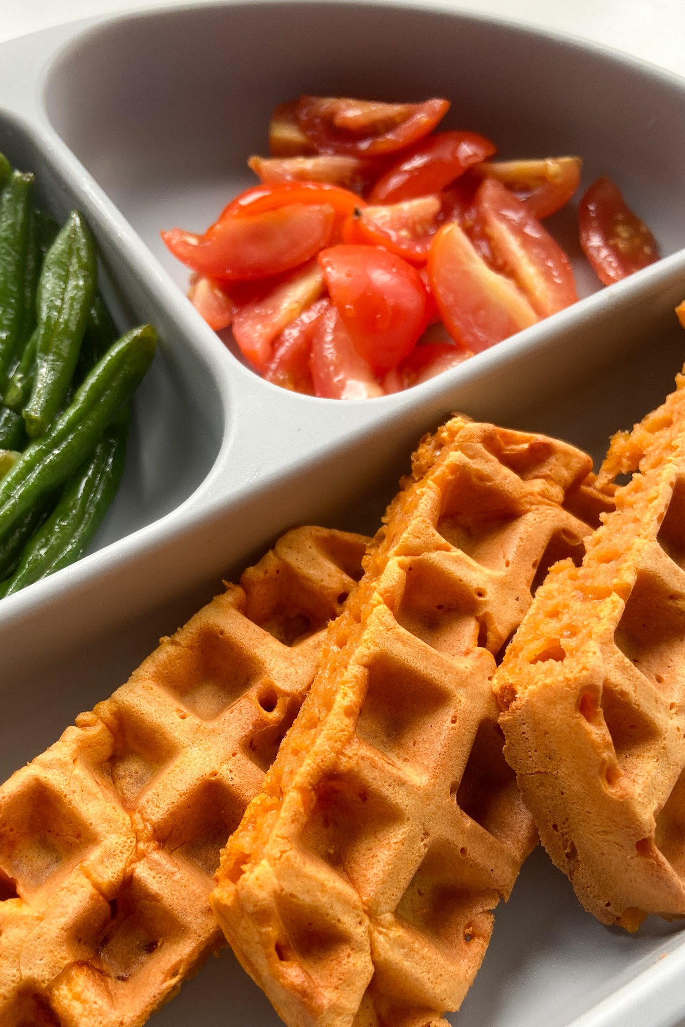 Pizza waffles served with green beans and quartered tomatoes