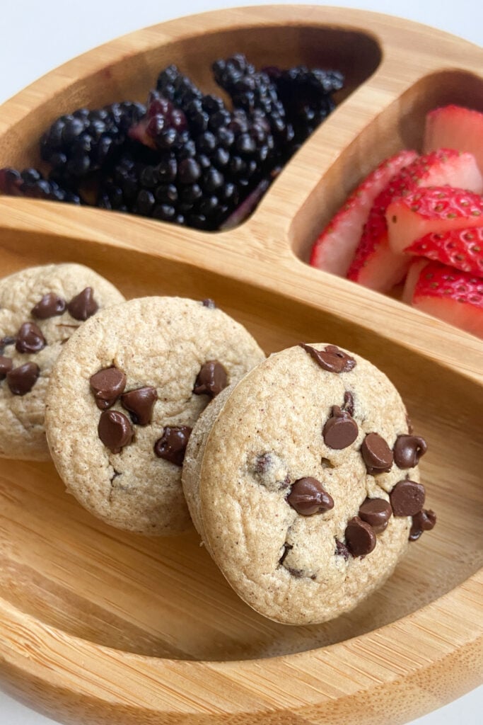 Chocolate chip oat muffins served with a side of quartered strawberries and blackberries