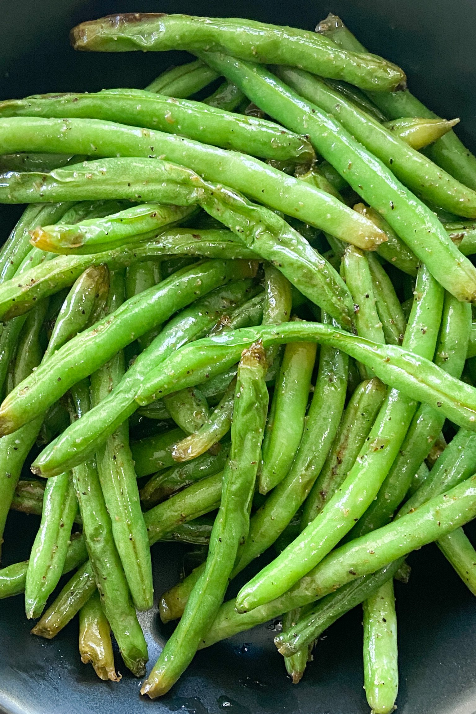 Air fryer green beans served on a black plate