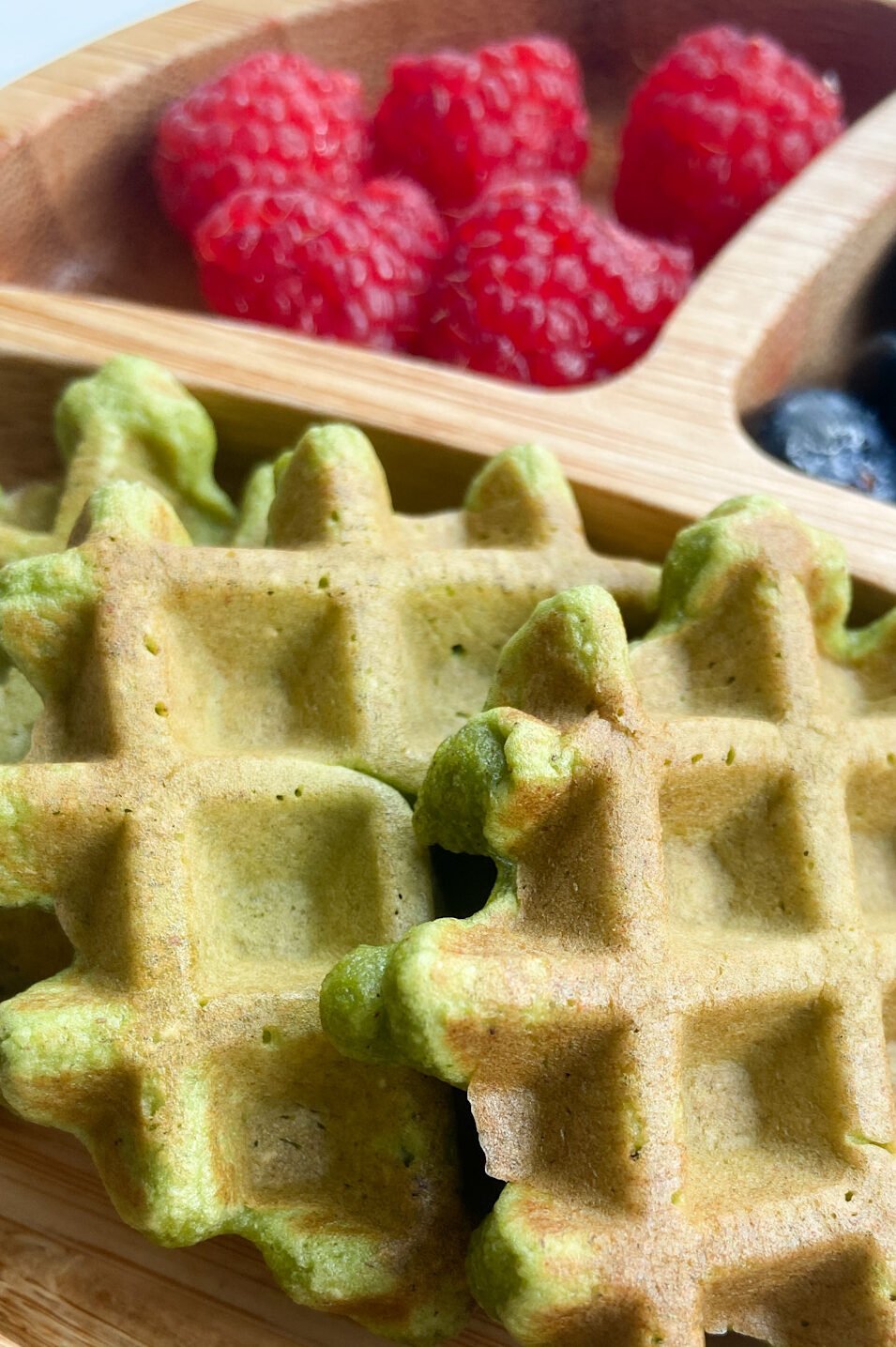 Spinach banana waffles served with raspberries and blueberries