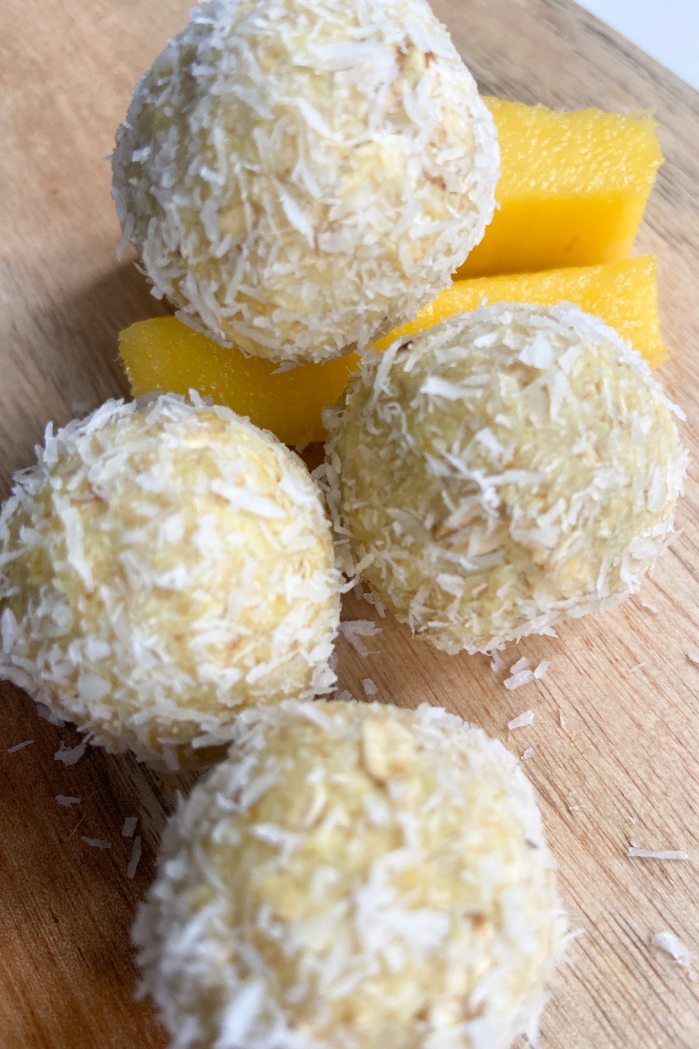 Mango bliss balls served with sliced mangoes
