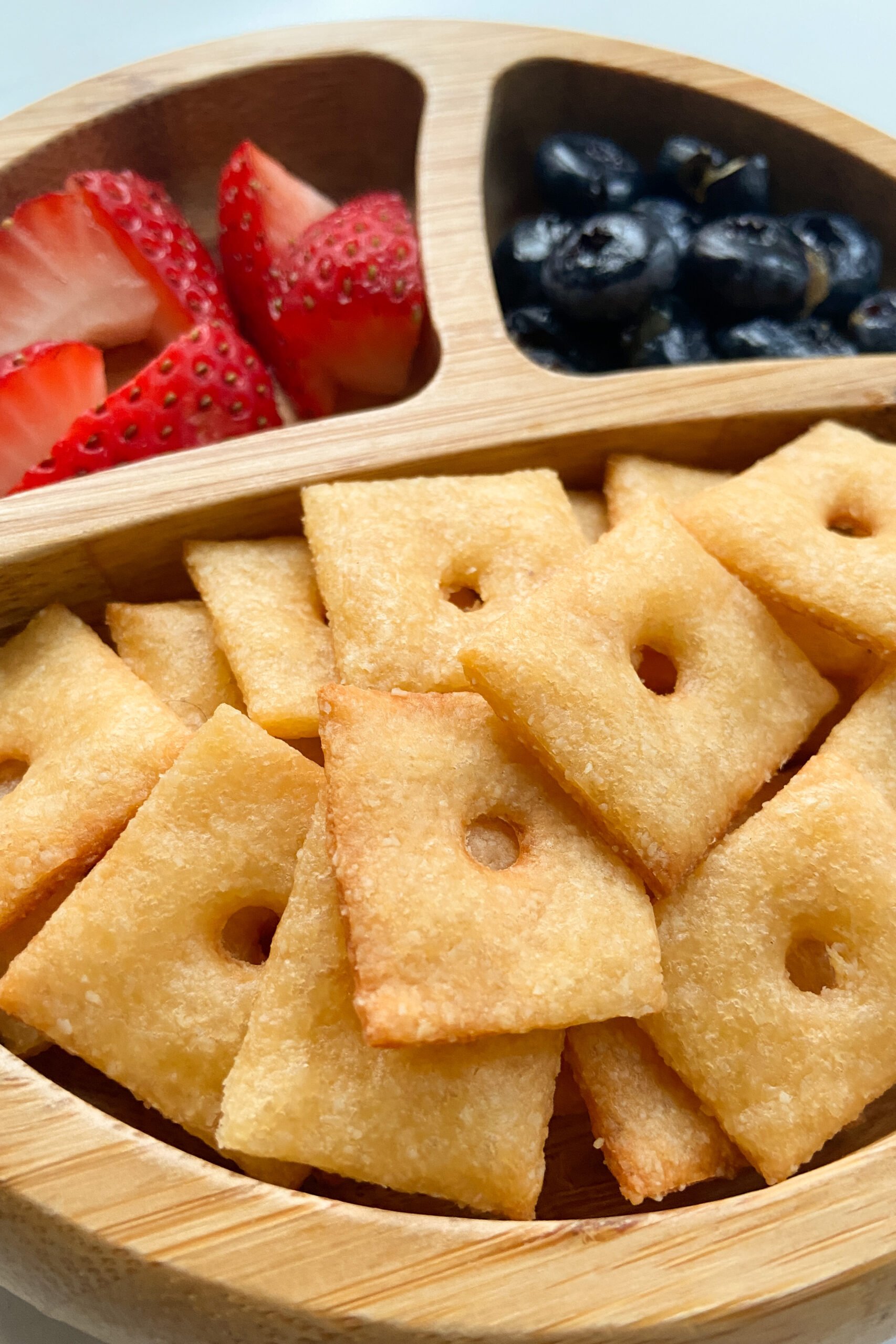 Homemade cheez-it crackers served with strawberries and blueberries