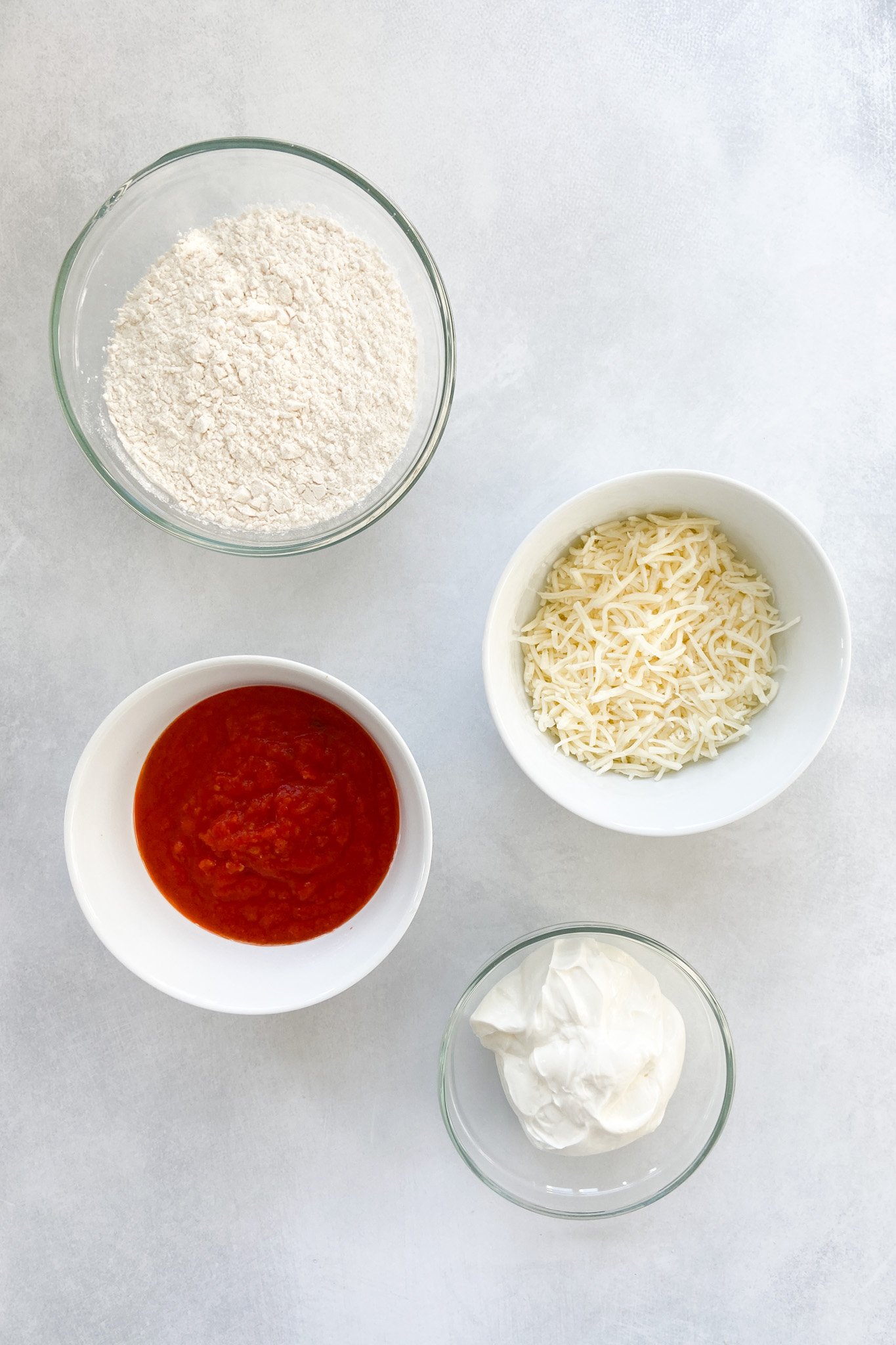 Ingredients to make homemade mini pizzas. Specifics provided in recipe card.