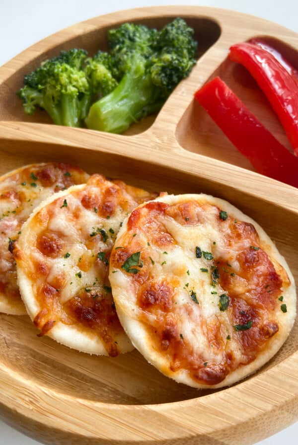 Homemade mini pizzas served with bell peppers and broccoli