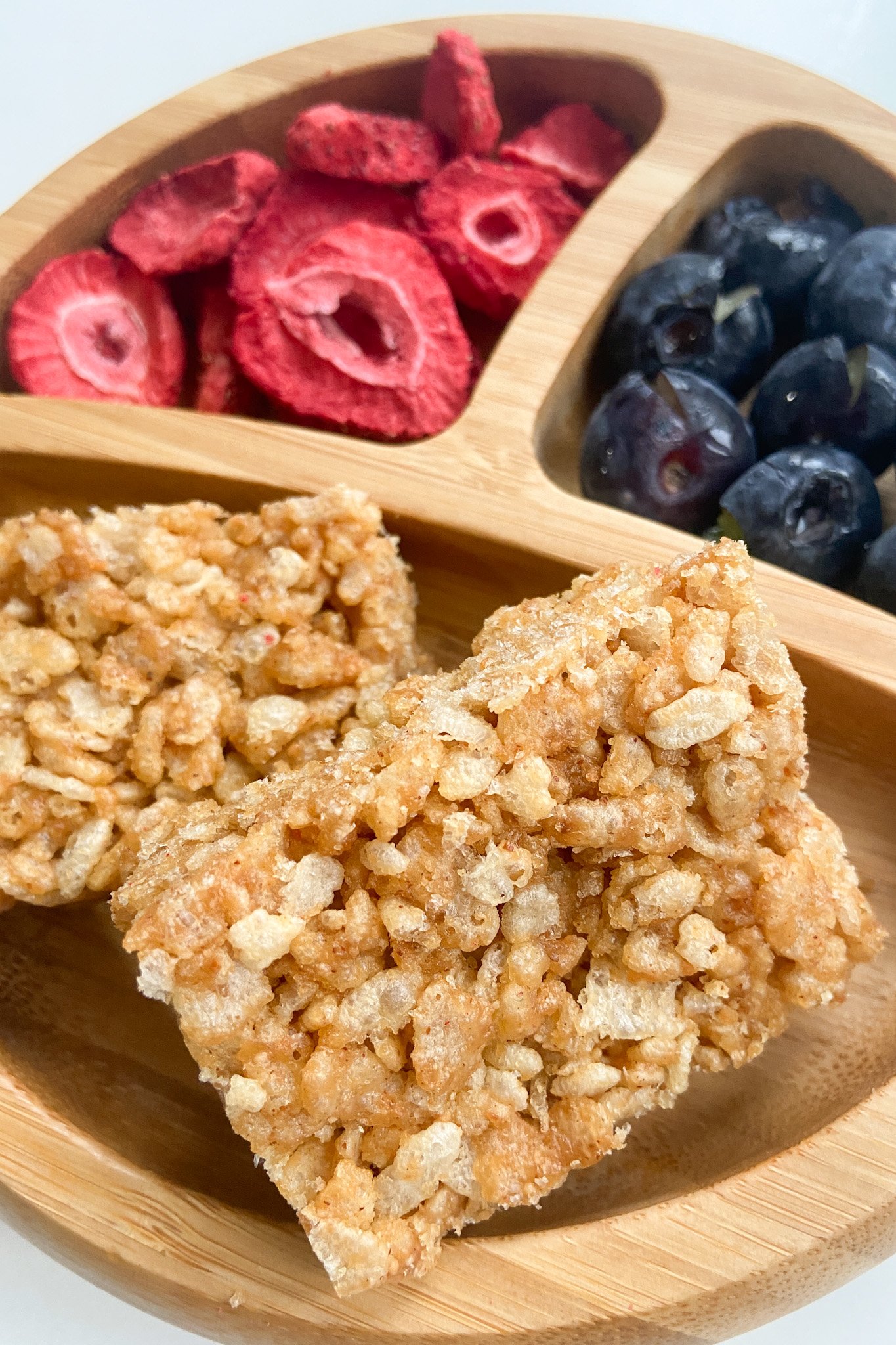 PB rice crispie treats served with freeze dried fruits and blueberries