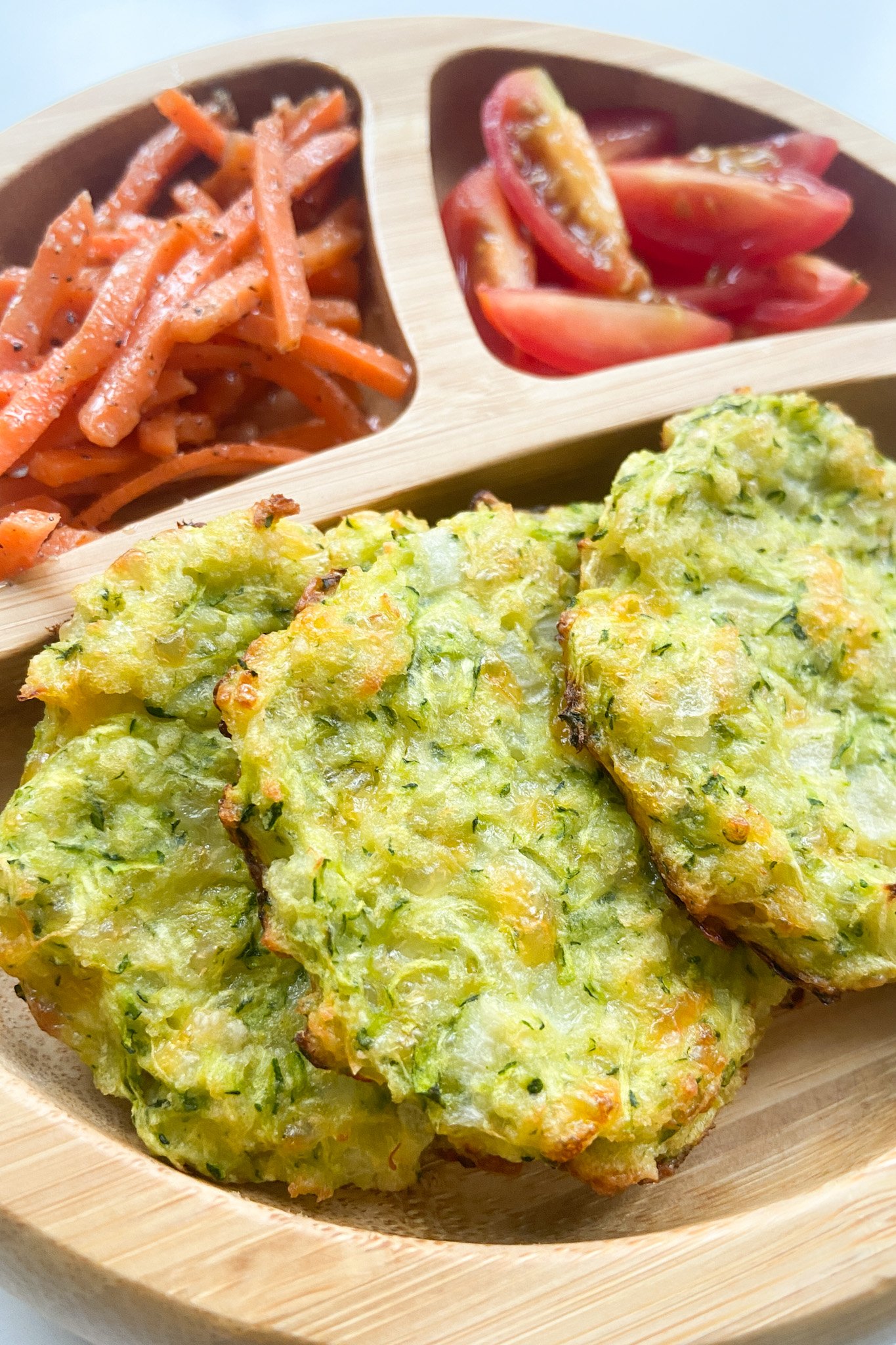Zucchini fritters served with carrots and tomatoes