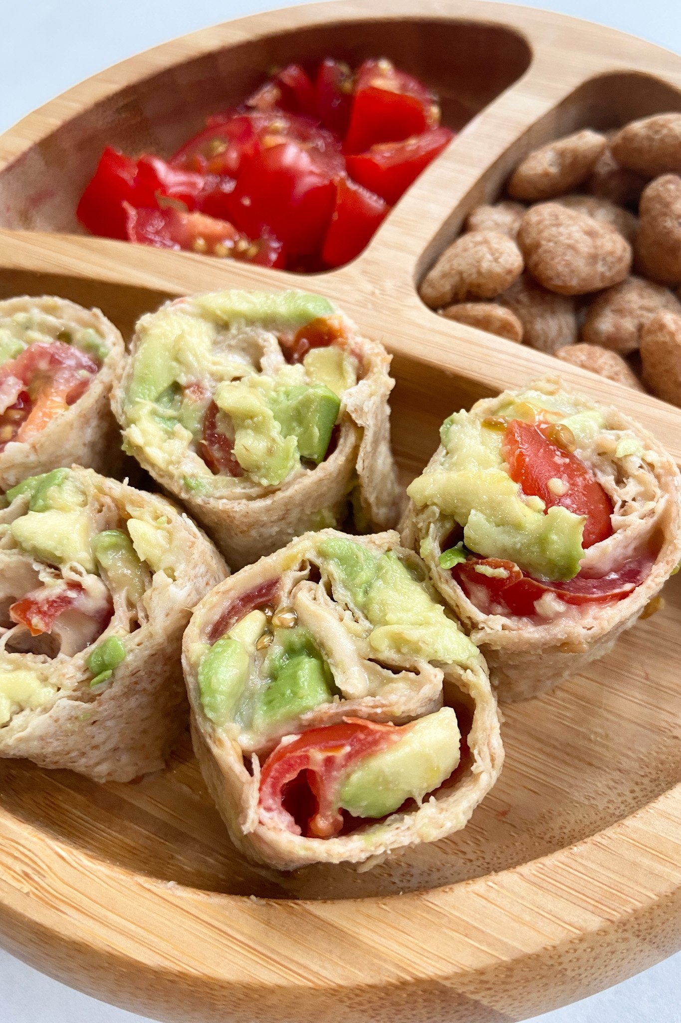 https://feedingtinybellies.com/wp-content/uploads/2022/01/Hummus-tomato-and-avocado-rollups.jpg