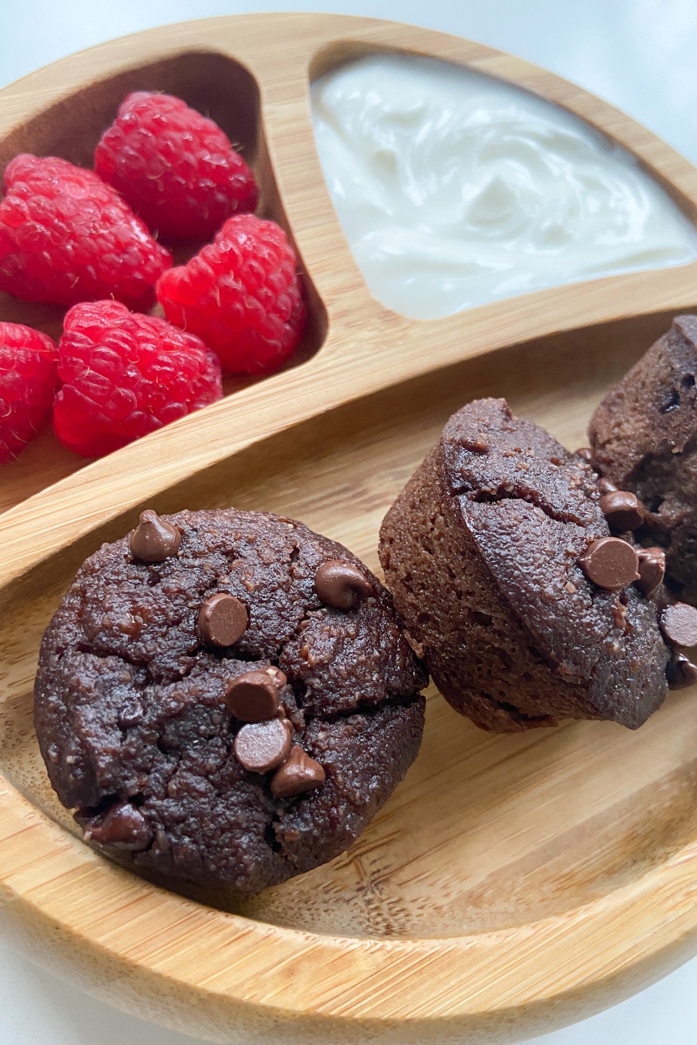 Mini double chocolate banana muffins served with raspberries and yogurt.