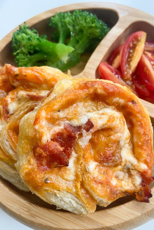 Pizza pinwheels served with broccoli and tomatoes