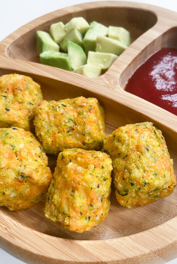 Zucchini carrot tots served with avocados and ketchup