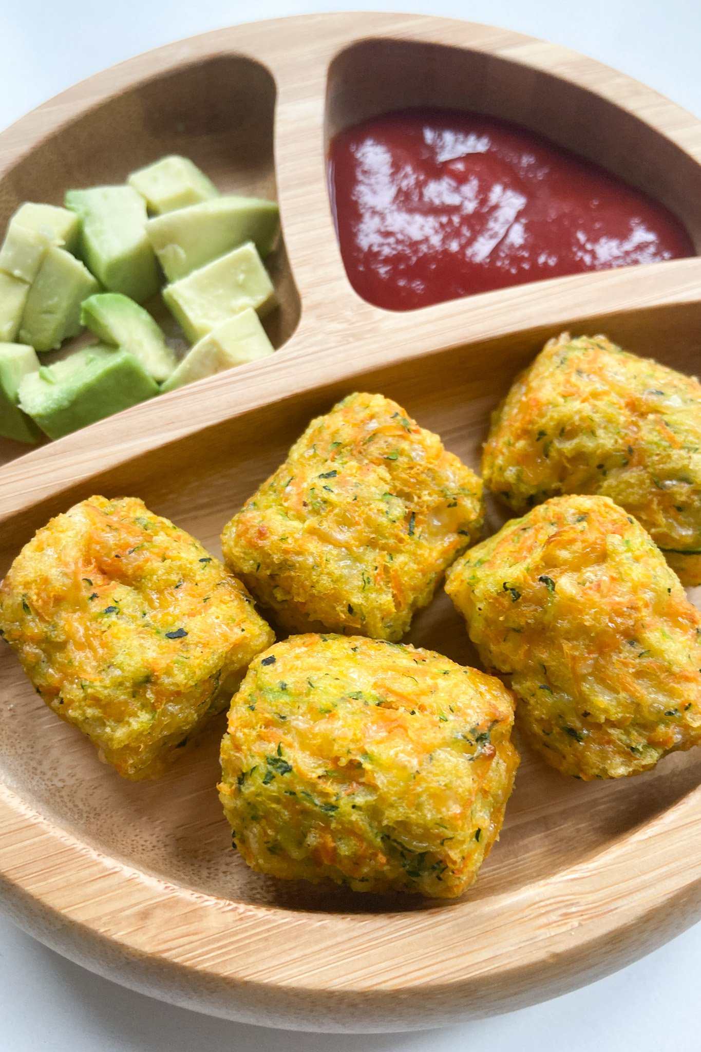 Zucchini carrot tots served with avocados and ketchup