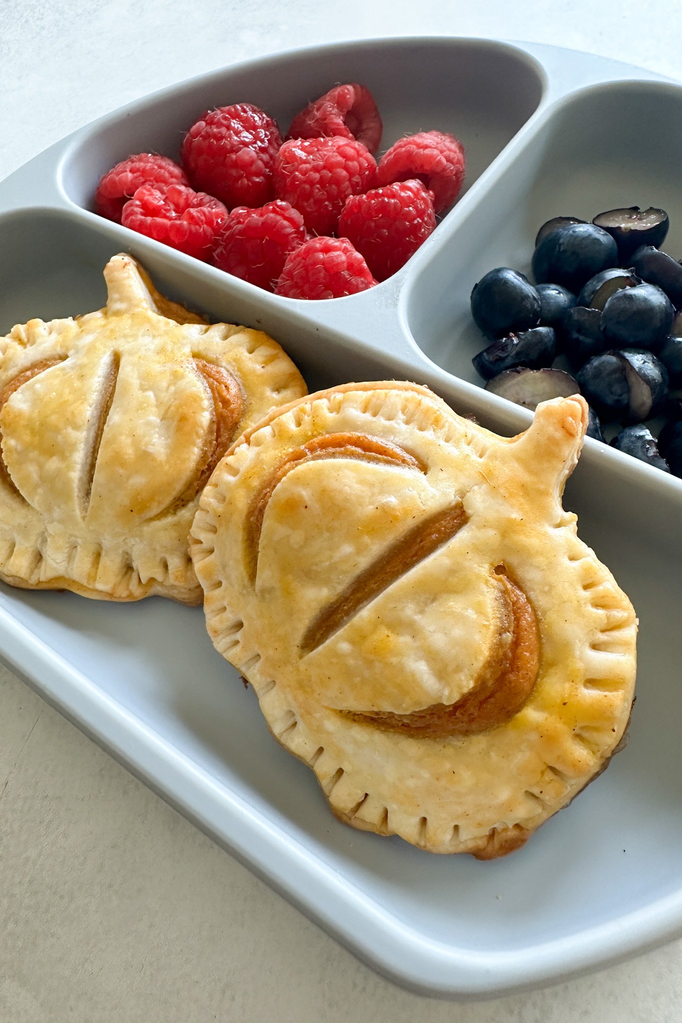 Pumpkin hand pies served with fruits.