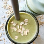 Spinach banana smoothies in toddler glass tumblers with silicone sleeves.