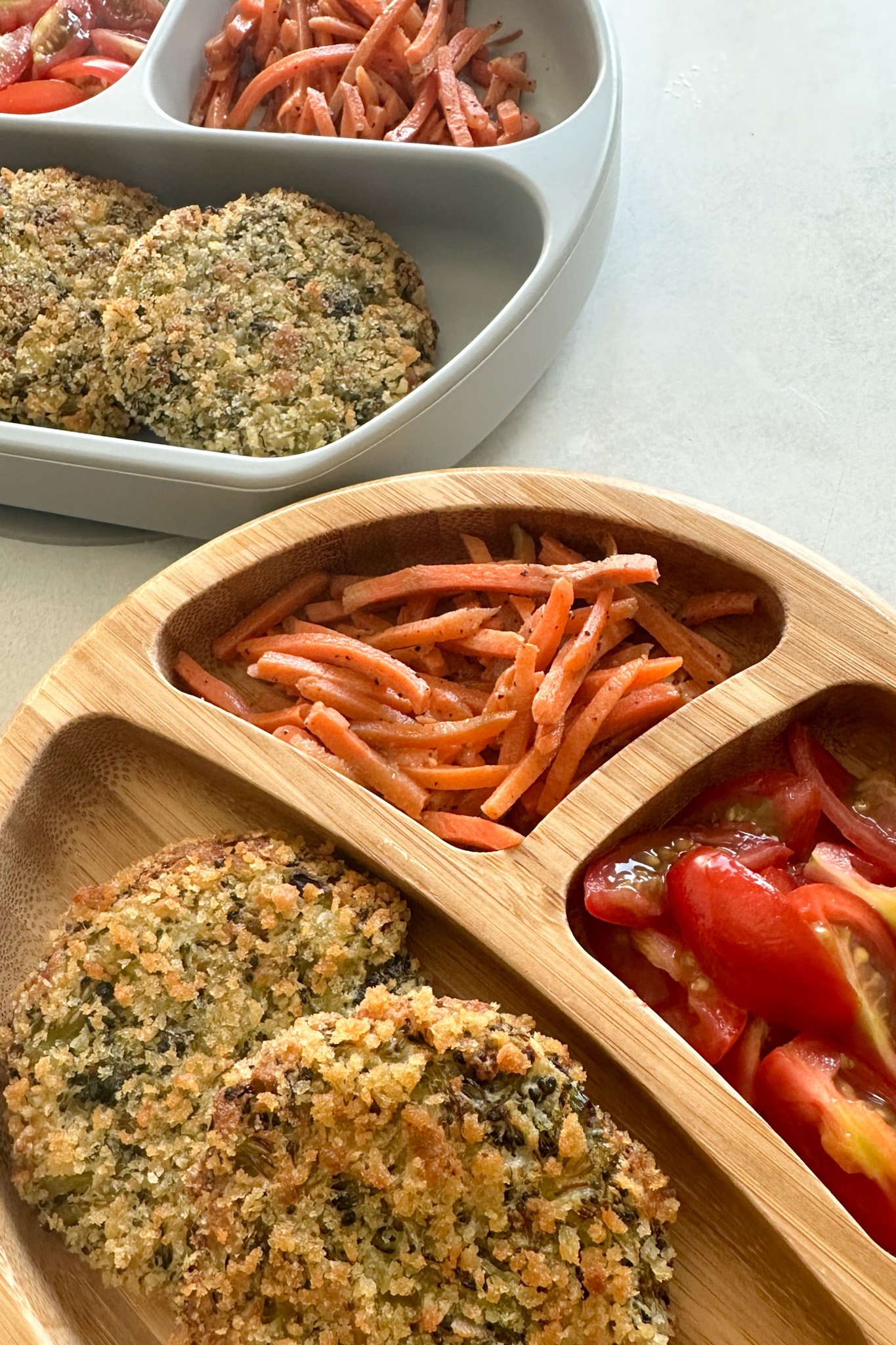 Broccoli patties served with carrots and tomatoes.