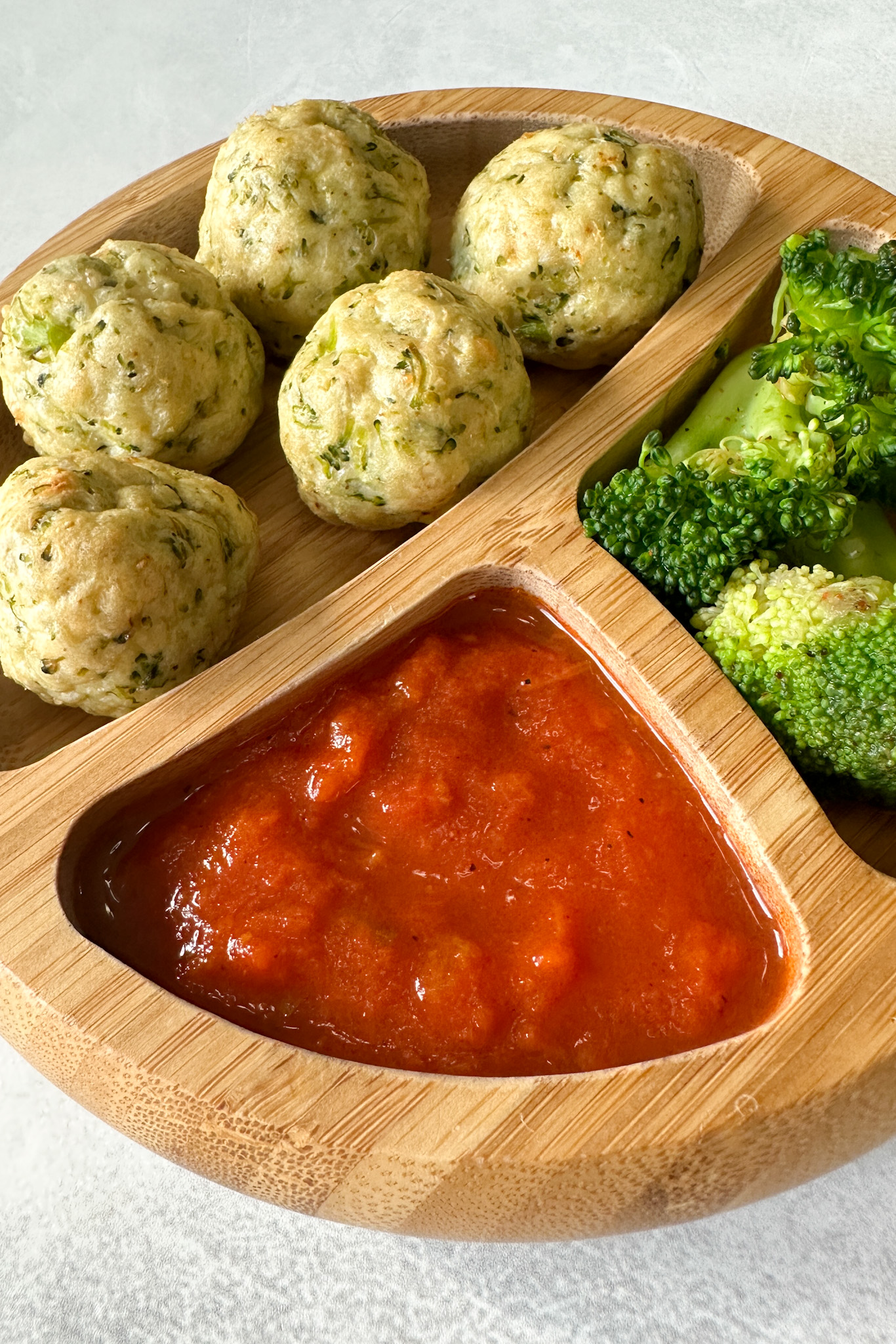 Chicken and broccoli meatballs served with marinara sauce.