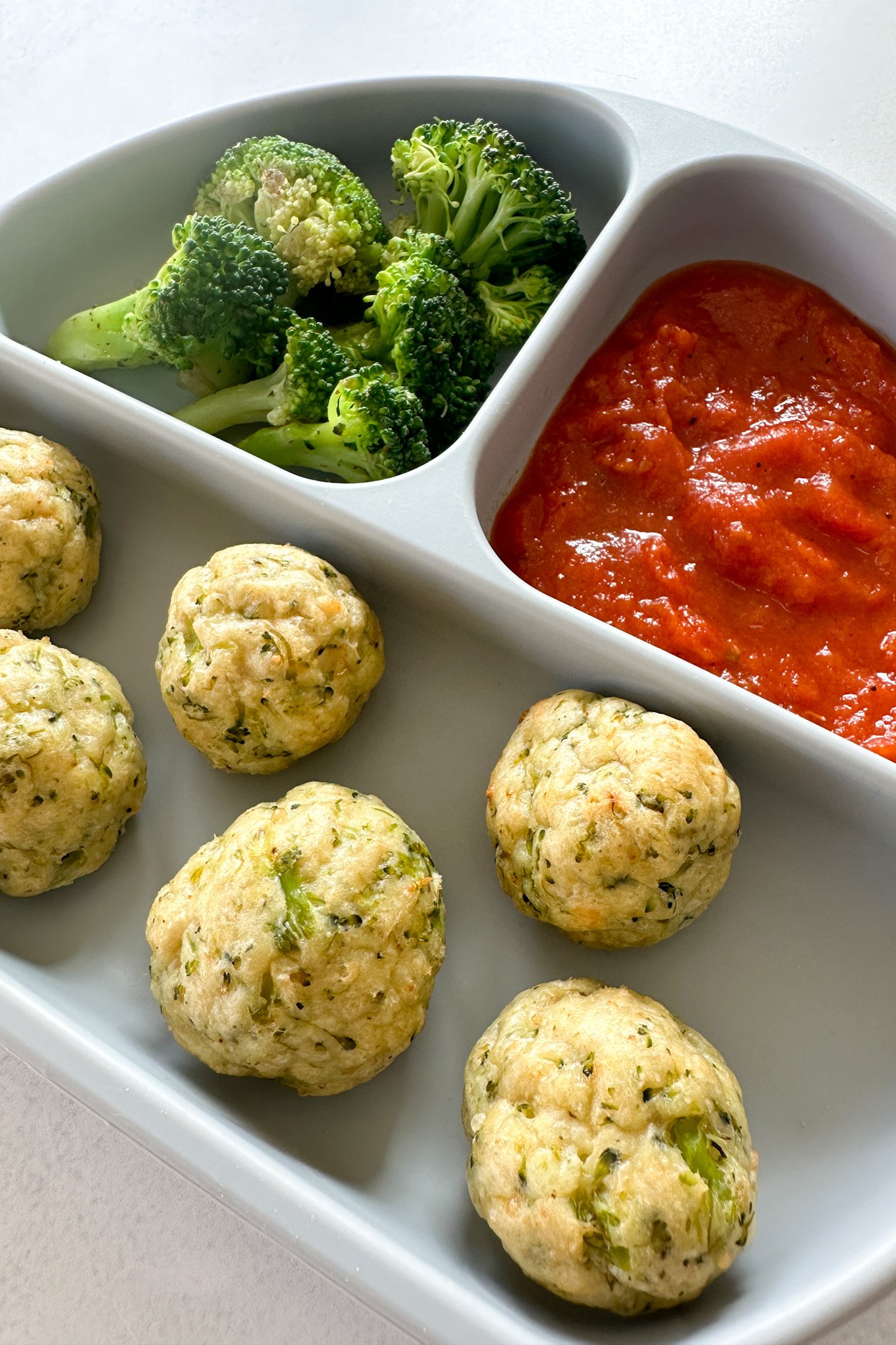 Chicken and broccoli meatballs served with marinara sauce.