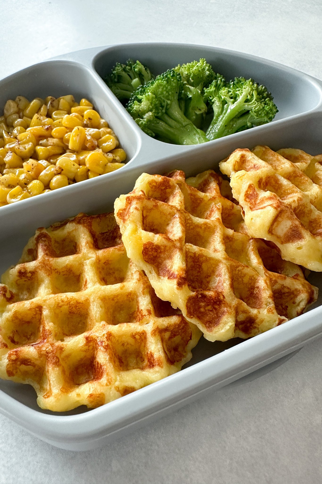 Leftover mashed potato waffles served with broccoli and corn.