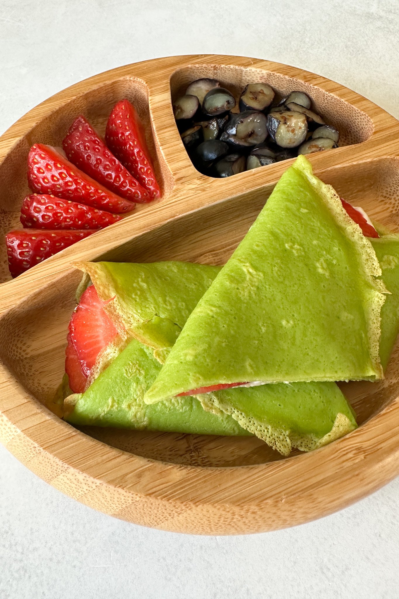 Spinach crepes filled with yogurt and strawberries.