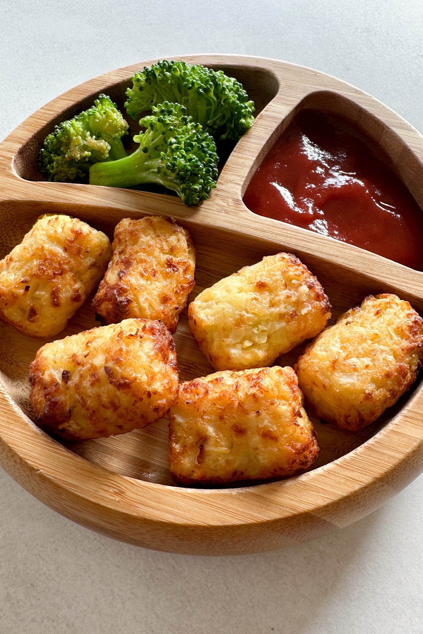 Air fryer cauliflower tots served with broccoli and ketchup.
