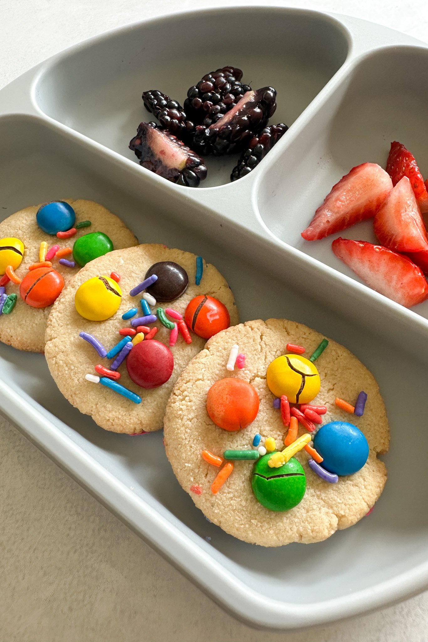 Chocolate chip almond cookies served with fruits.