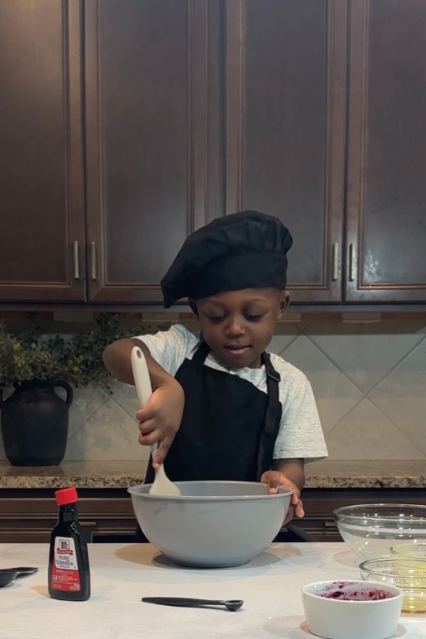 Toddler mixing ingredients in a bowl.