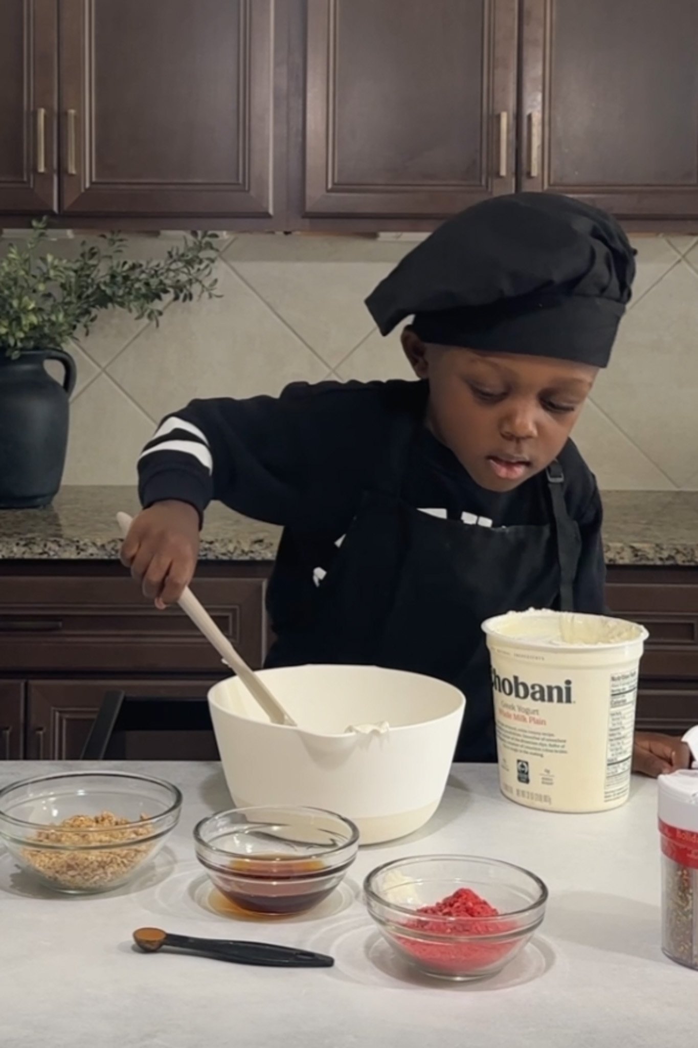 Toddler mixing recipe ingredients.